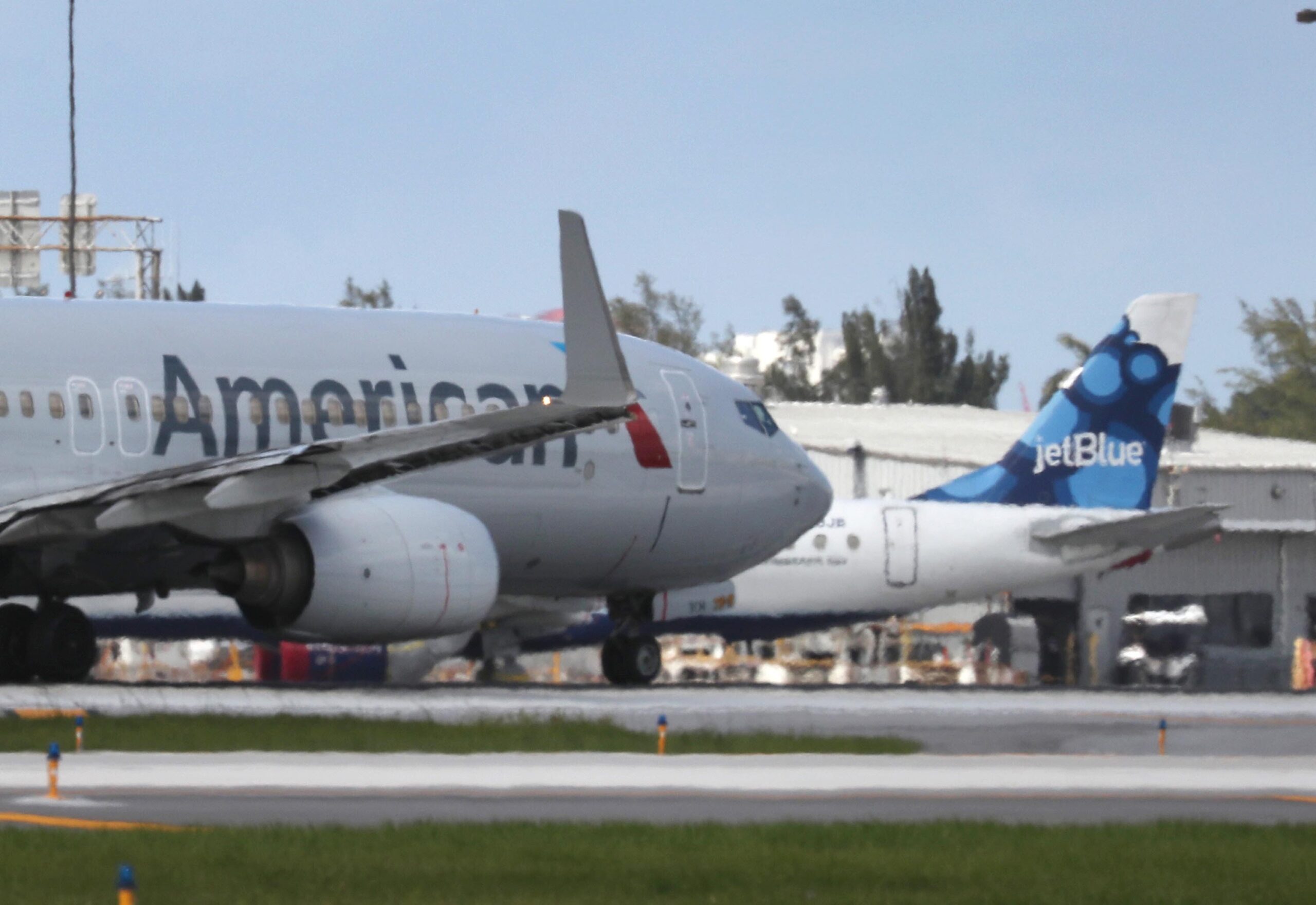 An American Airlines plane takes off near a parked JetBlue plane at the Fort Lauderdale-Hollywood International Airport on July 16
