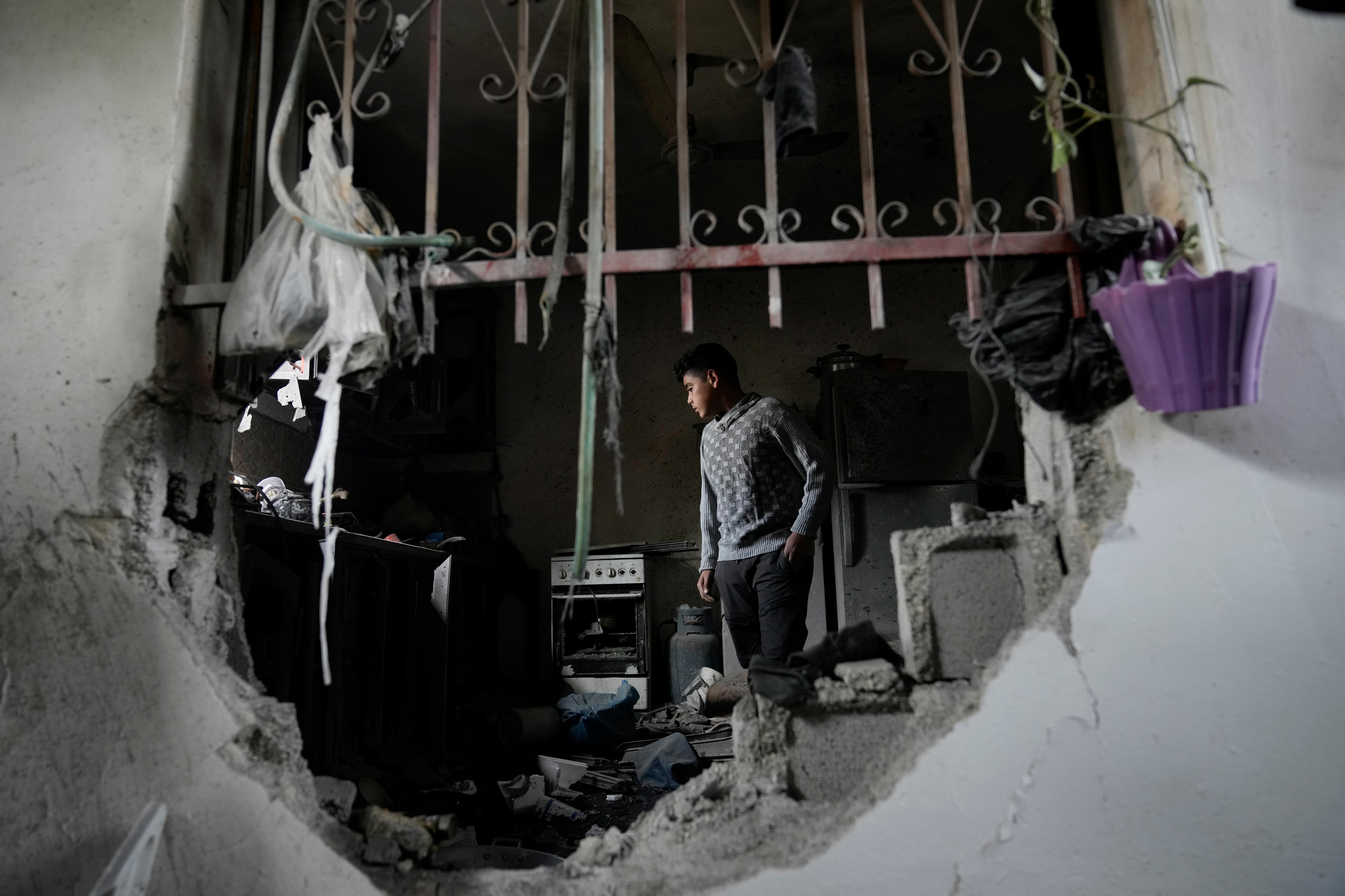 Palestinians inspect a house destroyed by Israeli forces during a...